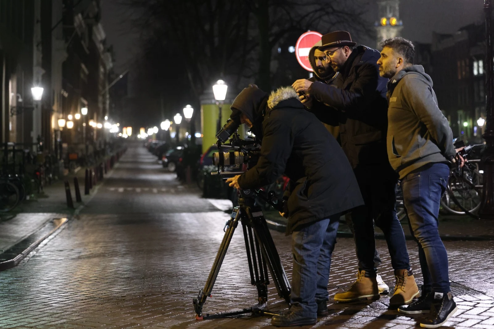 Film crew working around a camera on a night shoot