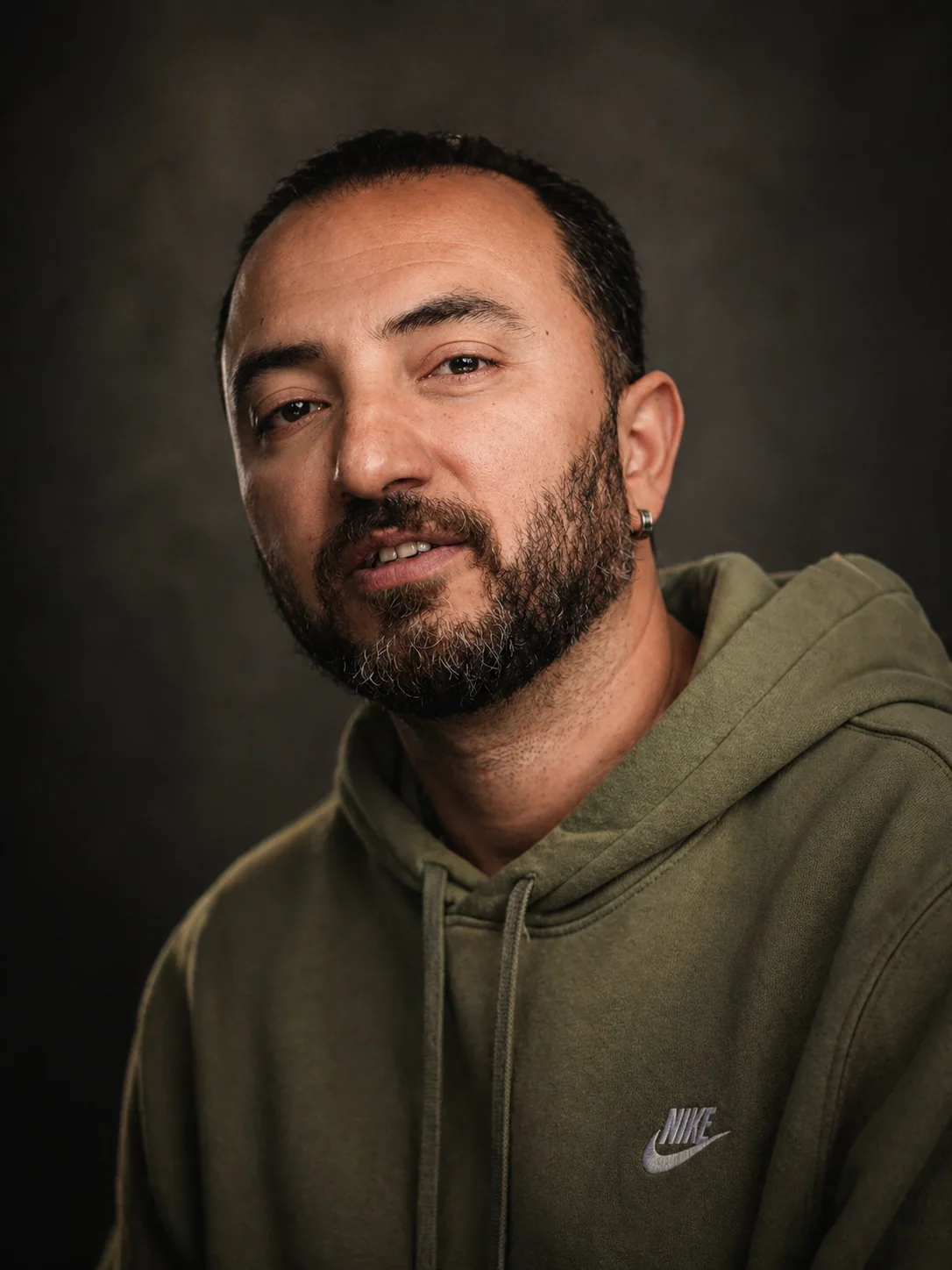 Cyrus Esfandiari in an olive hoodie, casual actor headshot
